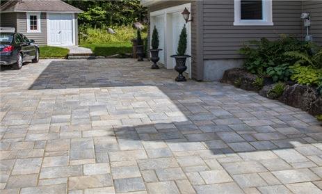 Large paver driveway with decorative border and planters